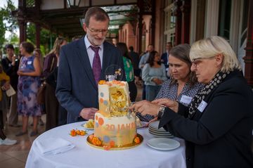 Drei Personen schneiden eine Torte in Stücke