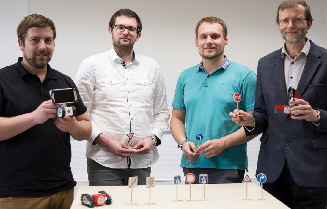 Vertreter der Hochschule Harz und Kinematics mit Spielzeug-Roboter Tinkerbots im Verkehrslernspiel