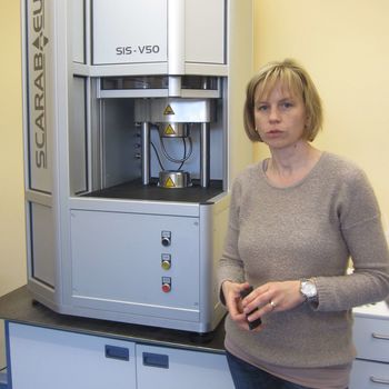 Porträtbild Frau vor Prüfmaschine zeigt Dr. Katja Oßwald