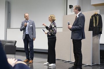 Drei Personen im Gespräch auf der Bühne