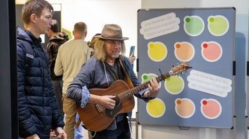 Ein Mann mit einer Gitarre spielt während des Gehens