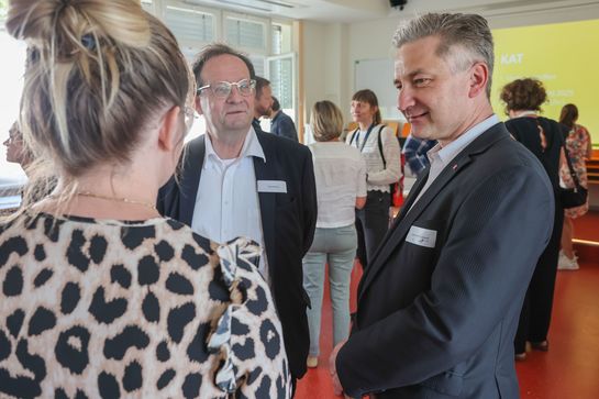 Drei Menschen unterhalten sich.