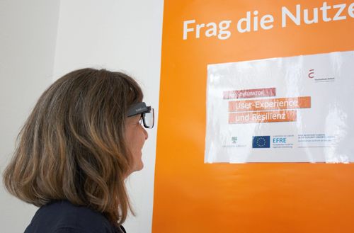 Kerstin Palatini mit Eyetracking vor Plakat User Experience_Resilienz Gründerlabor Hochschule Anhalt Digitales Planen und Gestalten KAT-Netzwerk