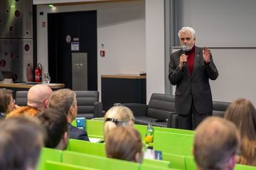 Willingmann steht auf der Bühne, im Vordergrund sitzen mehrere Menschen.