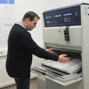 Mann an Maschine zeigt Dr Marcus Schoßig im Labor für Künstliche Bewitterung