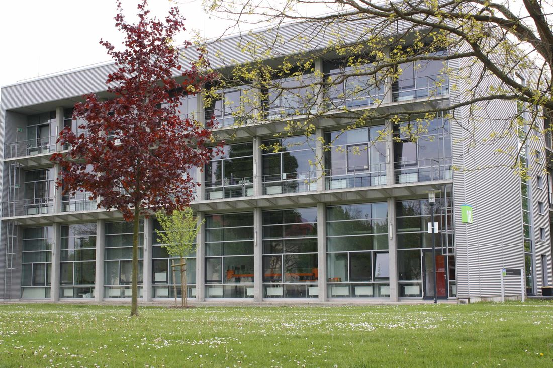 Mehrstöckiges Gebäude hinter grüner Wiese zeigt Industrielabor der Hochschule Magdeburg-Stendal.